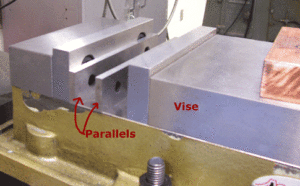 Parallels used to raise a part in a mill vise