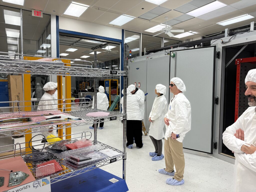 people wearing anti-static lab coats and hair coverings in a research lab