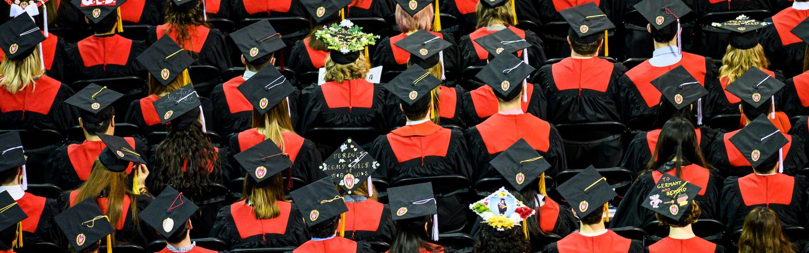 rows of graduates in regalia, sitting in chairs