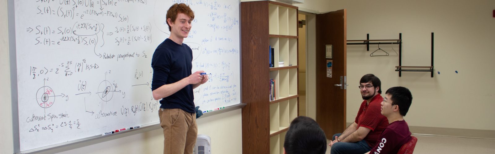 students working on a problem set at a white board