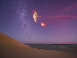 a starscape showing the milky way in the distance and a rendering of the gases surrounding the large magellenic cloud