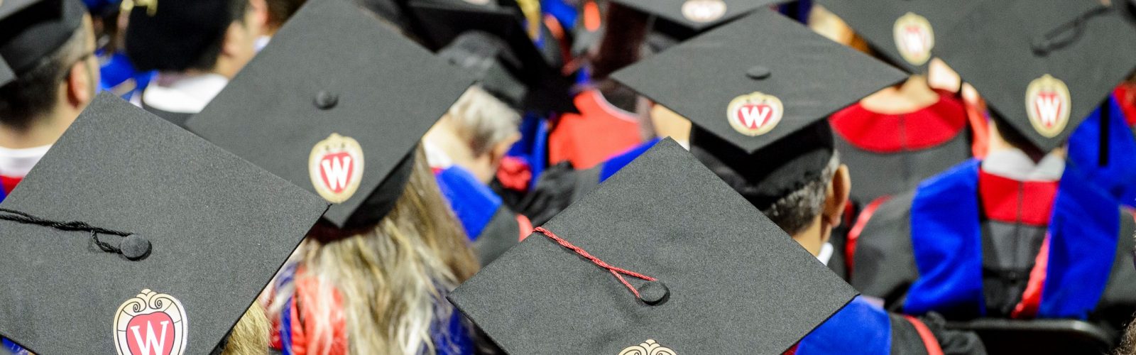 focus on graduation caps in a crowd of graduates