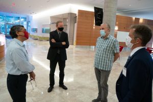 four faculty stand in a group outside the lecture hall