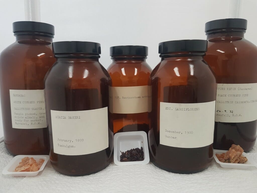 5 brown glass jars with pigment samples outside of them