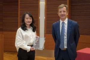 a woman holding a plaque and a man stand next to each other