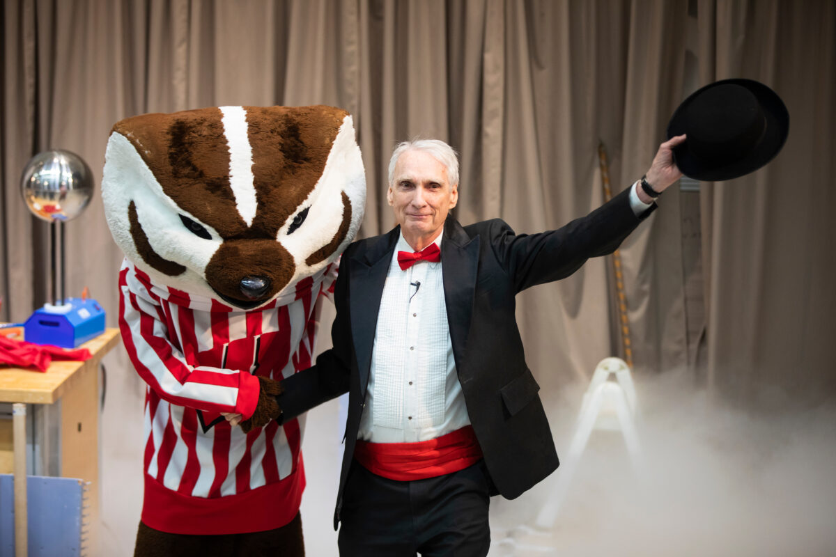 bucky badger, the mascot, shakes hands with a man in a tuxedo