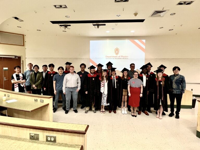 a group of students, some in graduation regalia, stand in a group