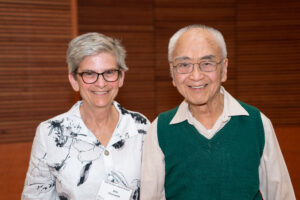 A woman on the left stands next to a man on the right