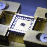 a metal block with a tiny square computer-chip-looking device sits in the middle of the metal block
