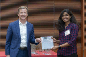 a man and woman both hold a glass plaque and are smiling