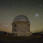 a dome-topped observatory is seen in long exposure in the night sky
