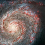 a whirled, wispy, spiral galaxy has white magnetic field lines overlaid on the image, showing that the magnetic field structure is organized in large, long structures over the entirety of the galaxy