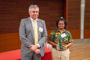 two people stand, one is holding a glass plaque