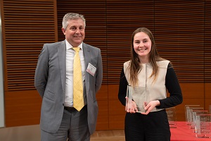 two people stand, one is holding a glass plaque