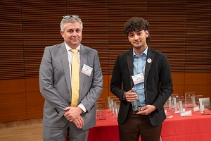two people stand, one is holding a glass plaque