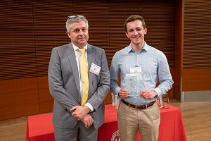 two people stand, one is holding a glass plaque