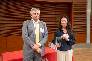 two people stand, one is holding a glass plaque