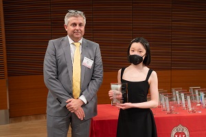 two people stand, one is holding a glass plaque